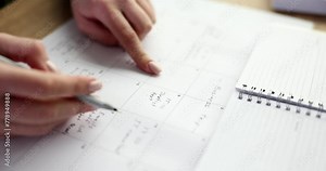 Female hands fill the business calendar, close-up. Personal information, planner. Monthly calendar