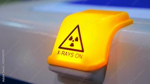 Warning sign about radioactive radiation ( x-ray ), bright yellow, on working equipment. Shot in motion