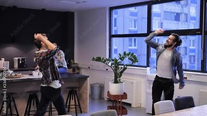 Two friends dancing and singing in the kitchen. Having good time on their break from work