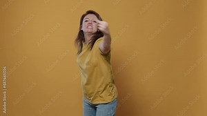 Angry woman having aggressive attitude problem being rude and disrespectful in studio. Unhappy person showing middle finger obscene hand gesture showing aggresion and anger.