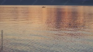 Reveal shot of Lake Atitlan Guatemala with fishing boat during sunrise, aerial