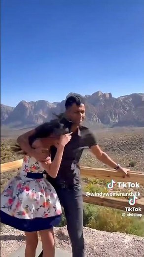 Girl in knee length dress in strong wind