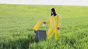 Woman throwing away plastic bottle in garbage can. Environmental damage by plastic waste.Environmental conservation