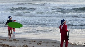 'Surfing Santas' hit the beach in holiday tradition