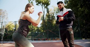 Young girl and man exercising outside. Athletic woman and man doing exercise. Sporty man and woman doing lunges on one leg to strengthen the muscles of the thighs and buttocks. Personal trainer. Stock Video
