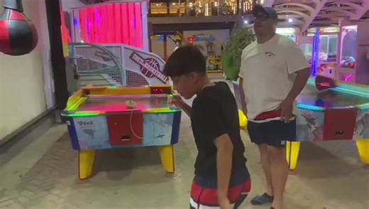 Young Boy Thrills at Boxing Arcade Machine