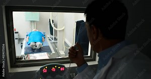 Doctor using x-ray unit control panel on patient