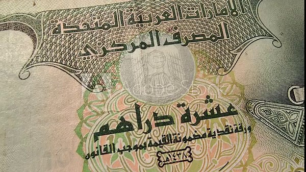 United Arab Emirates dirham (AED) national central bank currency note extreme closeup macro top view. UAE recession, inflation, economy, international money, investment, loan and reserve cash concept.