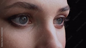 Makeup artist applies the shadow to the eyelid with a brush. Extreme close-up on a black background. Selective focus.