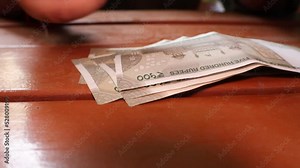 Stacking 500 denominations of Indian rupees. Close up of hand counting Indian Money. 4K video. New Indian currency notes. 500 Indian Rupee notes. paying in cash.