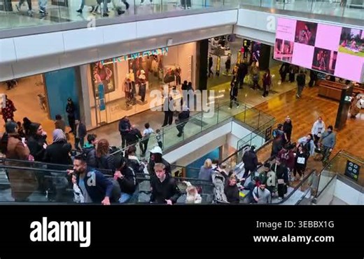 London, UK - October 27, 2025:Crowd of shoppers moving up and down escalators in a shopping center, symbolizing consumer activity, retail environment, busy lifestyle, and modern urban commerce Stock Video Footage - Alamy