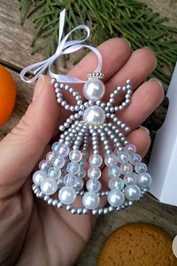 36K views · 158 reactions | I made this little angel using pearl beads, small silver beads, and thin wire. First, I shaped the head and wings, then threaded the beads to create the flowing skirt. After securing the wire, I added a ribbon loop so it’s easy to hang. #Christmas #christmasdecor | DIY Crafts and Projects | Facebook