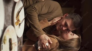 Passionate young couple having a romantic candlelight dinner at home, girl with boyfriend celebrating Valentine Day talking and enjoying time together