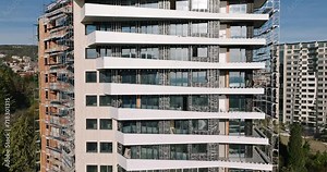 Aerial view Building siding Exterior of new house city apartment building facade close up, windows, balconies, scaffolding in sunset at sunset background. Skyscraper Building Process of Construction