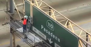 Daring man caught on camera altering freeway sign