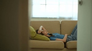 Unhappy painful moment Young woman suffering from headache or stress on sofa in living room. Female depression stress at home. Healthcare concept.