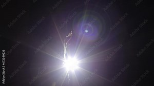 Hip hop dancing silhouette. Dance in the dark, a boy dances at night. Man makes dynamic movements, modern style. The light from the flashlight, he dances in the city near the house