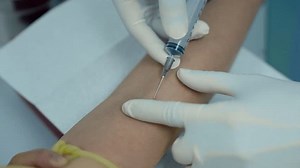 4K, Slow, close-up blood collection needle tube which doctor's hand is holding, about pierce patient's arm, Doctor's hand wearing rubber gloves press for blood vessels in arm for cleanliness safety.