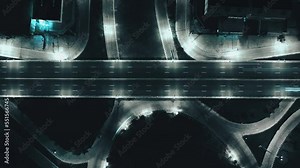 Time-lapse of car traffic transportation on road at junction intersection, 4K. Aerial view of road interchange or highway intersection with busy urban traffic speeding on the road at night, IoT GPS 5g