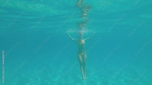 Snorkeling, beautiful young caucasian woman swim in transparent sea water. Freediver snorkeling with a snorkel and fins
