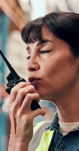 clip-3990528169-woman-talking-logistics-radio-warehouse-schedule-inventory