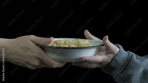 Feed the homeless. A homeless hungry child is given a plate of porridge.