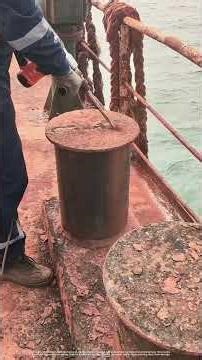 Using An Electric Chisel To Clean Rust Off A Mooring Bollard On A Fishing Vessel