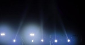 flashing and rotating light beams from stage lights on a construction during musical performance