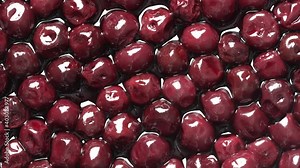 Cherries in alcohol in their own juice in a plate, close up, top view. Fresh ripe red cherry soaked in alcohol on plate rotates