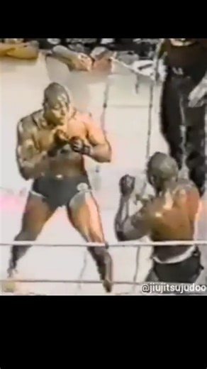 jiujitsu/judo - oldschool on Instagram: "Carlão Barreto vs Kevin Randleman - 1997. Em 1997, Kevin Randleman, discípulo do bicampeão do UFC Mark Coleman, lançou um desafio provocador: esperava um representante do jiu-jitsu com coragem para enfrentá-lo. A declaração inflamou a comunidade da luta no Rio de Janeiro. A organização do evento foi precária. O octógono prometido não chegou, e os promotores improvisaram com um ringue antigo de boxe. Uma das cordas se rompeu e foi substituída por uma corda