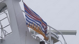 Provincial flag of British Columbia waving on top of the BC Ferries Coastal Inspiration vessel on its way to Vancouver Island in British Columbia, Canada