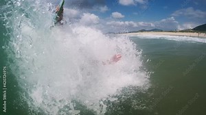 Bodysurfing with handboard, handplane. Young man rides the barreling fun wave using his body and handboard