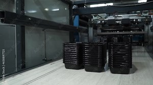 Industrial production of plastic food containers. Disposable black plastic containers at the factory.