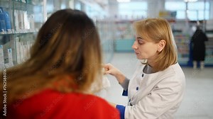 The pharmacist explains to the client all the nuances of using the drug. She holds the product manual in her hands. High quality 4k footage