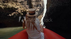 Woman sitting on boat passing lagoon. Back view female travel, riding on gondola, sitting on ship bow and looking enjoy beautiful nature in a wicker hat in summer day. Tourism, travel, nature concept.