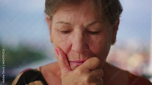 Pensive senior old lady close-up face in deep thought. Contemplative senior older woman in dilemma pondering solution to problem