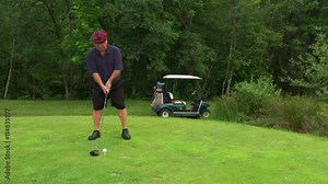 Golfer in plaid cap approaching ball on tee and driving it out of frame to right