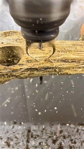 drilling a precise hole in a dry wood branch on a table surface using a manual power drill machine