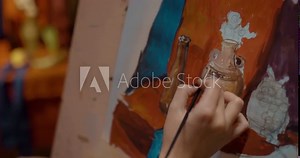 Close-up, painting on easel, lesson at art school. Female hand with an artistic brush draws a still life, draws the details. Artist's hand applies paint to the painting with a brush. 4k, ProRes Stock Video