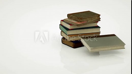 A stack of old books falls onto a white surface and is held in place, while the top one falls and flies to the side.