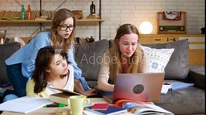 young female student becomes nervous and upset, because computer laptop breaks down and she loses everything, while studying seriously with friends together at home to prepare for difficult exam test