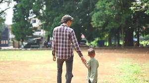 Father and son walking together, showcasing a strong family bond and shared moments. Perfect for projects focused on family, parenting, or quality time spent outdoors.