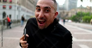 Happy hispanic man dancing in street. Excited latin guy dances in joy