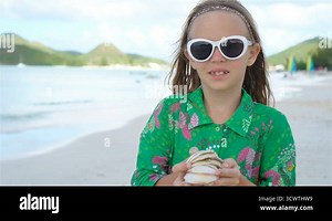 Little cute girl with seashell in hands at tropical beach Stock Video Footage - Alamy