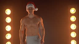 Portrait of muscular man wearing Christmas Santa hat, standing...