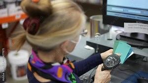 Closeup slow motion of woman wearing face mask color scanning paint chips with computer in a hardware store. Concept of coronavirus shopping experience.