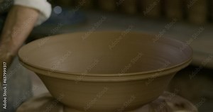 Hands of a master potter working on a potter's wheel in the manufacture of dishes