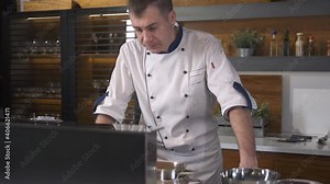 Professional Chef in a modern Restaurant Kitchen. Smart Technology in futuristic Kitchen. Cook using Interface Control Panel on Stove. Equipment for preparation Food. Slow motion Close up