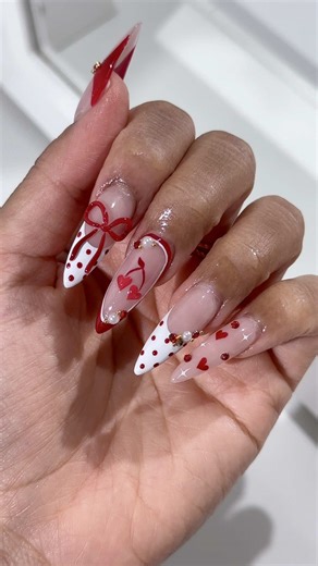 valentine’s day nails loading 💋♥️ red polka dot french tips, with a 3d bow, cherry hearts, pearls, rhinestones & starburst details. is this the beginning of a love story? would you wear these nails for valentines day?👀💌 save for nail inspo share with your nail bestie ♥️ #valentinesnails #luxurynails #3dnailart #nailinspo #polkadotnails