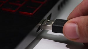 Connecting a USB cable to a computer, hand plugging device into USB port